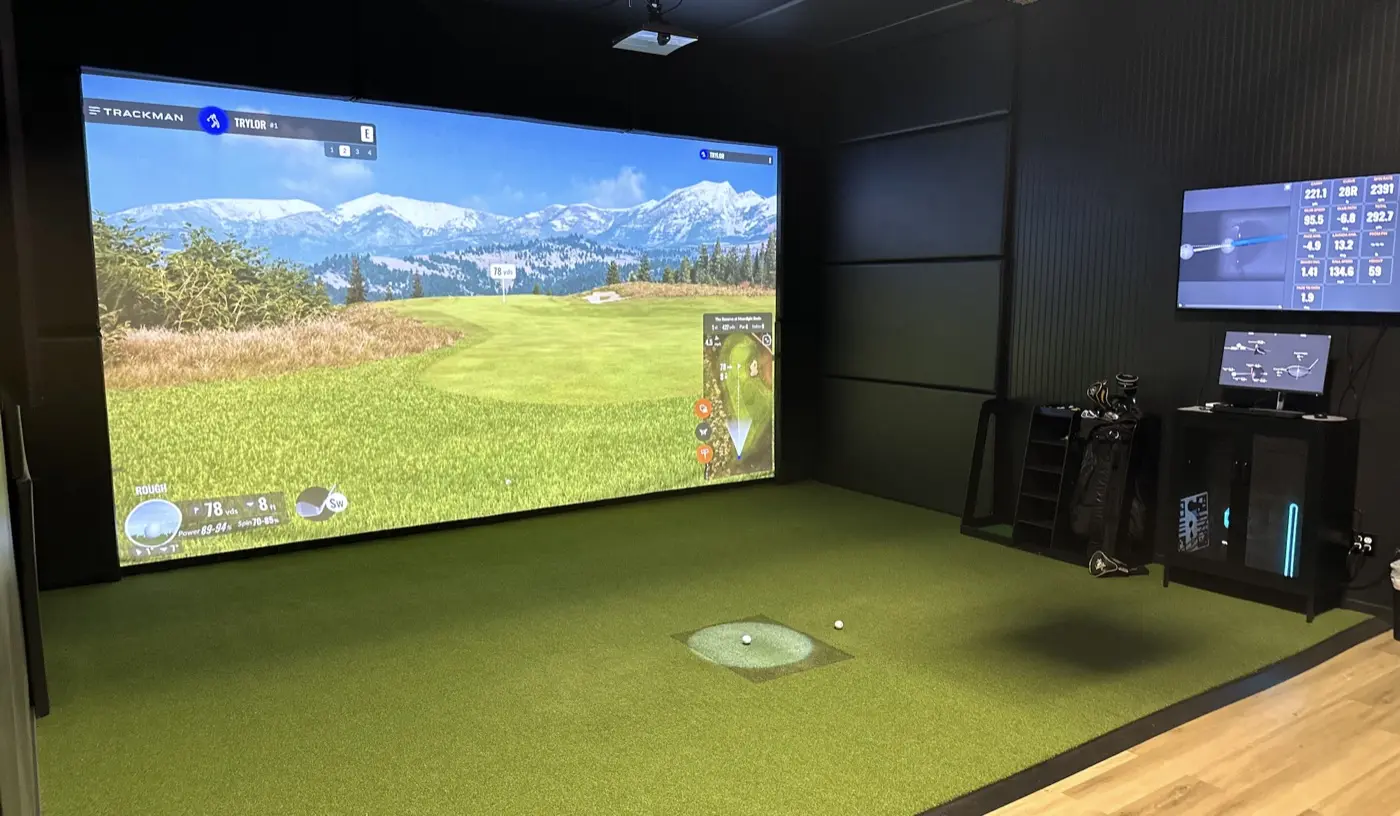 Bay 1 at Pin High: an 18ft-wide 4K simulator screen showing a mountain golf course, TrackMan IO hitting mat and data display